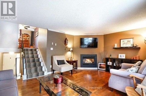 A living room with a grey couch, a coffee table, a fireplace, and a television.