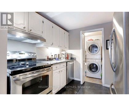 A modern kitchen with white cabinets and stainless steel appliances.