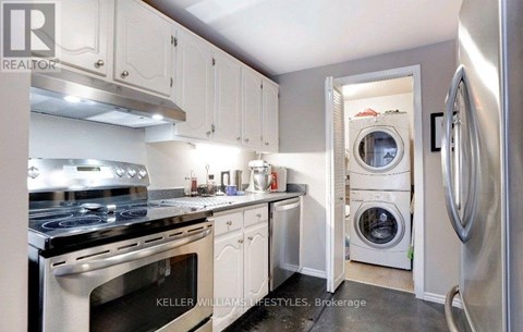 A modern kitchen with white cabinets and stainless steel appliances.