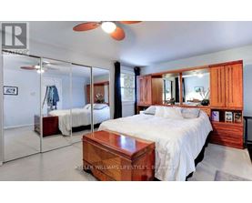 A bedroom with a large bed and a ceiling fan.