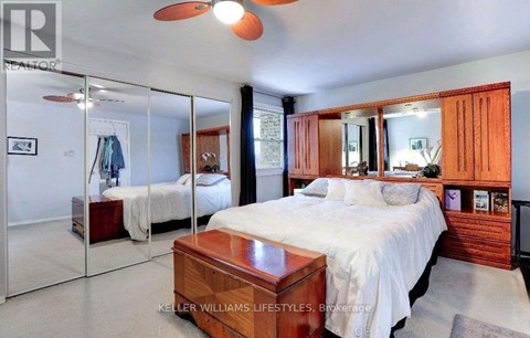 A bedroom with a large bed and a ceiling fan.