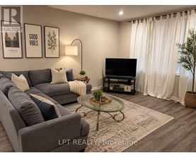 A living room with a grey couch, a glass coffee table, and a flat screen TV.