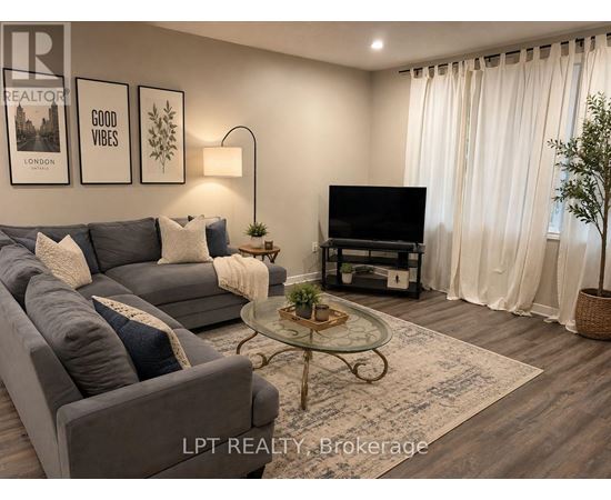 A living room with a grey couch, a glass coffee table, and a flat screen TV.