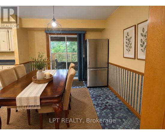 A dining room with a wooden table and chairs.