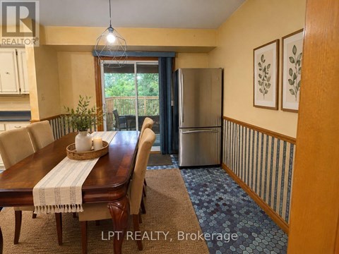 A dining room with a wooden table and chairs.