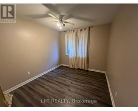 A room with a ceiling fan and a window with curtains.