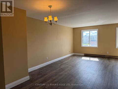A room with a chandelier and a window.
