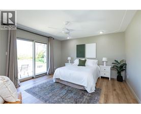 A bedroom with a large bed and sliding glass doors.