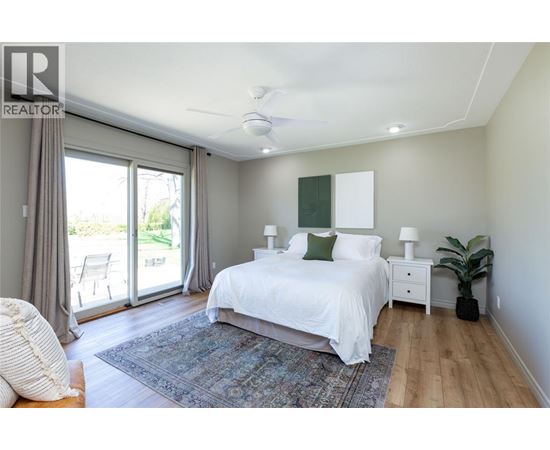 A bedroom with a large bed and sliding glass doors.