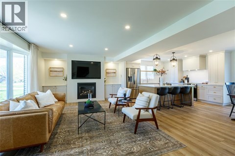 A living room with a fireplace and a television on the wall.