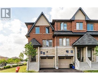 A large brick house with a garage and a sign that says Century Paramount Realty.
