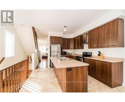 A kitchen with wooden cabinets and a marble countertop.