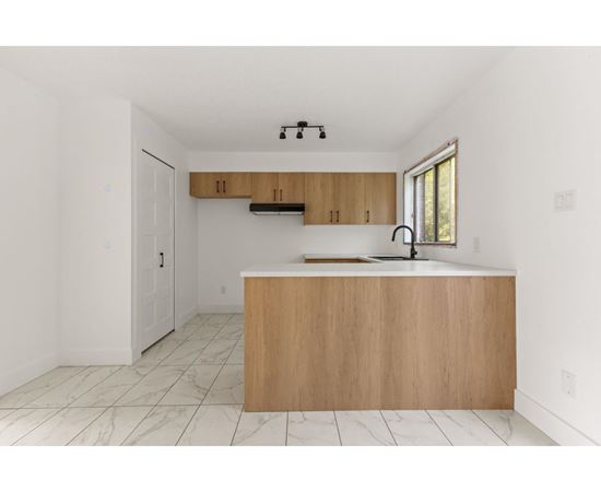 A kitchen with a wooden island and a window.