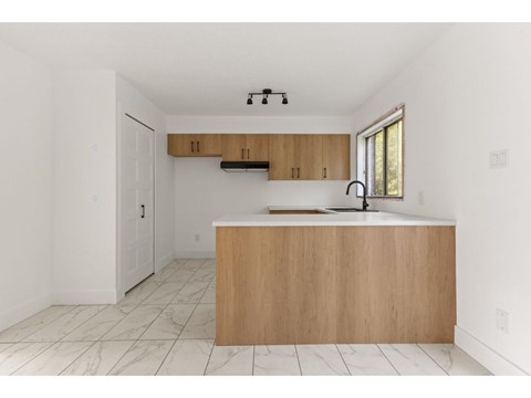 A kitchen with a wooden island and a window.