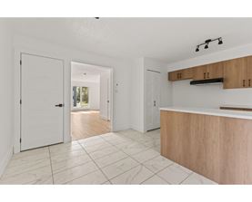 A white interior with a wooden counter and tile flooring.