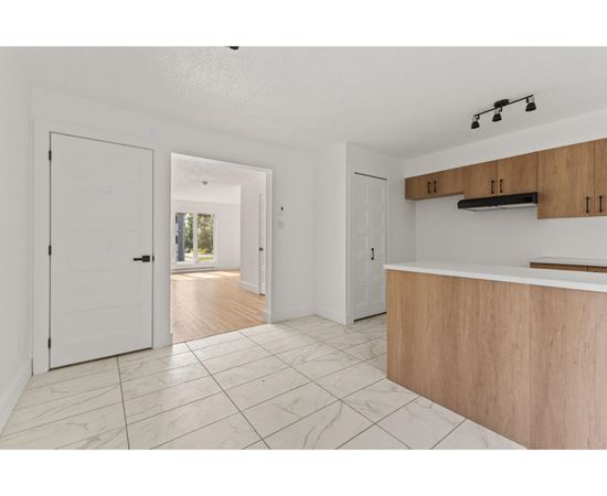 A white interior with a wooden counter and tile flooring.