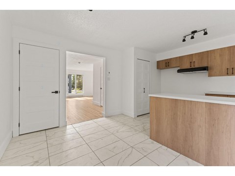 A white interior with a wooden counter and tile flooring.