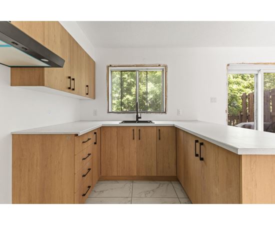 A kitchen with wooden cabinets and a window.