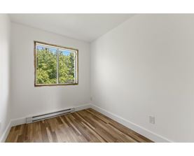 A room with a window showing trees outside.