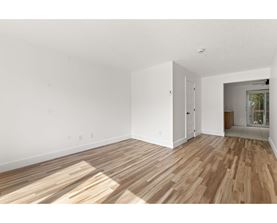 A room with wooden flooring and white walls.