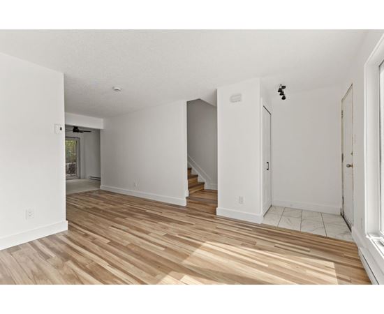 A room with wooden flooring and white walls.