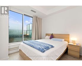 A bedroom with a large bed and a window overlooking a field.