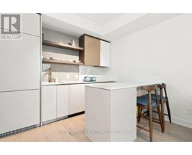 A kitchen with a white counter and a bar stool.