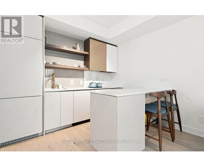 A kitchen with a white counter and a bar stool.