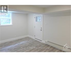 A room with a door and a window, with a REALTOR sign on the wall.