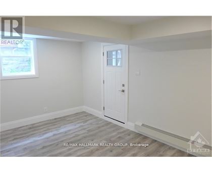 A room with a door and a window, with a REALTOR sign on the wall.