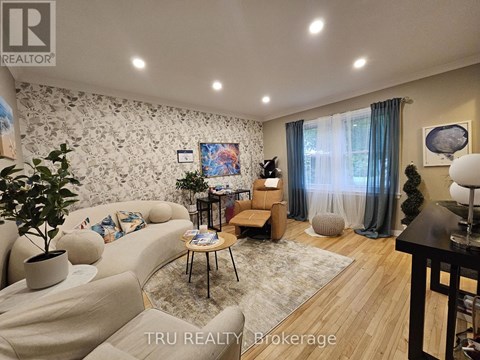 A living room with a couch, a chair, a table, and a painting on the wall.