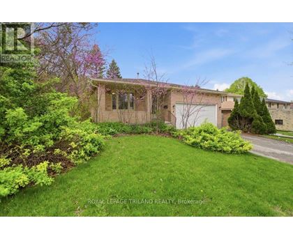 A house with a green lawn and trees in the background.