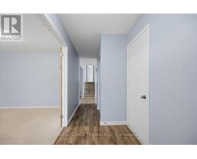 A hallway with a staircase leading to the second floor.