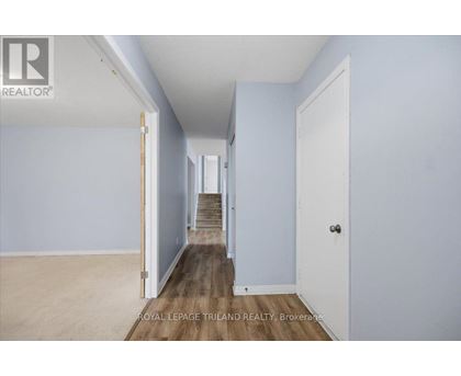 A hallway with a staircase leading to the second floor.
