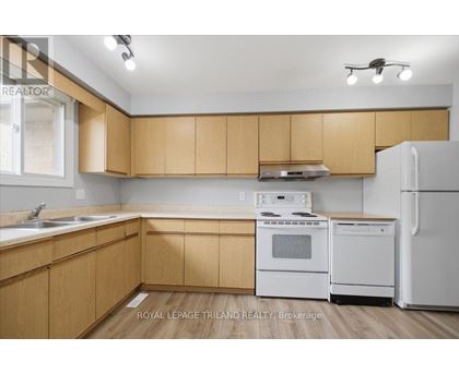 A kitchen with wooden cabinets and white appliances.