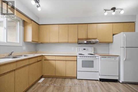 A kitchen with wooden cabinets and white appliances.
