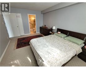 A bedroom with a large bed and a rug on the floor.