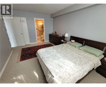 A bedroom with a large bed and a rug on the floor.
