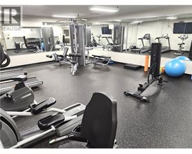 A gym with a variety of equipment including treadmills, weights, and exercise balls.