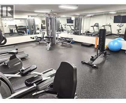 A gym with a variety of equipment including treadmills, weights, and exercise balls.