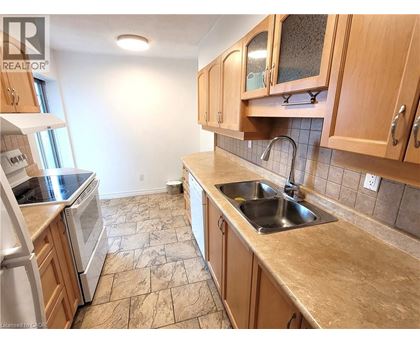 A kitchen with wooden cabinets and a tiled floor.