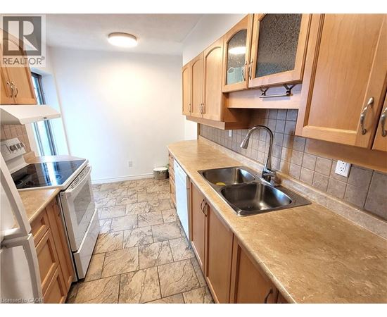 A kitchen with wooden cabinets and a tiled floor.