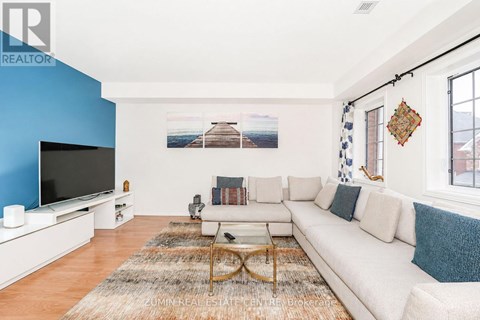 A living room with a white couch and a television.