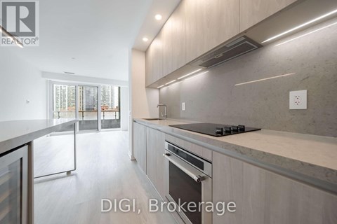 A modern kitchen with a stainless steel oven and a marble countertop.