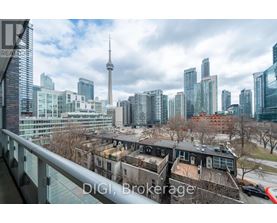 A cityscape with a mix of modern and older buildings, with the CN Tower visible in the background.