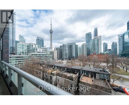 A cityscape with a mix of modern and older buildings, with the CN Tower visible in the background.
