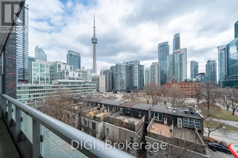 A cityscape with a mix of modern and older buildings, with the CN Tower visible in the background.