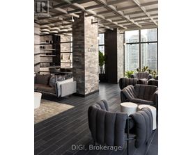 A modern living room with a stone pillar and grey furniture.
