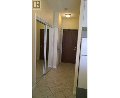A hallway with a white refrigerator on the right side.