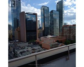 A cityscape with tall buildings and a bridge in the foreground.
